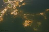 Aerial photo of little islands and underwater formations surrounded by deep water.