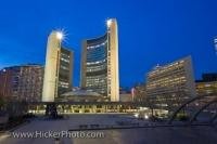 The City Hall building and the Nathan Phillips Square, both recognizable landmarks in downtown Toronto are lit up at dusk as night falls on the city. The City Hall opened in 1965 and is still a marvel of architectural design today.