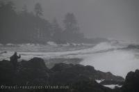 A tourist stands on the rocks as an immense storm rages through Cape Scott National Park in British Columbia, Canada.