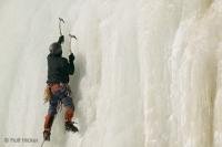 Step by step an ice climber, climbing in Quebec, scales the ice formations of Montmorency Falls.