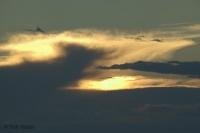 A mix of wispy and dark clouds form above L'Anse aux Meadows during sunset on the Northern Peninsula of Newfoundland.