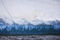 Grooves, gouges and trickling water show the wearing down and melting of an iceberg as it journeys through Iceberg Alley in the Atlantic Ocean off the coast of Newfoundland, Canada, a popular location for iceberg watching.