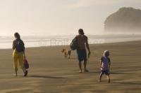 Pictures of families, showing Piha Beach on the North Island of New Zealand, a preferred kiwi family beach