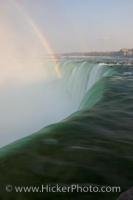 A rainbow arcs in the mist of the Horseshoe Falls in the City of Niagara Falls in Ontario, Canada as the river empties over the cliff.