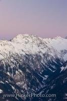 The sunset over the snowcapped mountains of the Hohe Tauern National Park turns the sky and the snow shades of soft pink, as can be seen from this viewpoint of the ski field of Wildkogel in Salzburger Land, Austria. This park is a protected habitat.