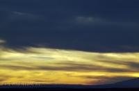 Dark clouds threaten a bright sunset image along Highway 95 in Utah, USA.