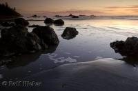 The silhouetted rocks along Ruby Beach on the Olympic Peninsula of Washington, USA contrast against the sunset light.