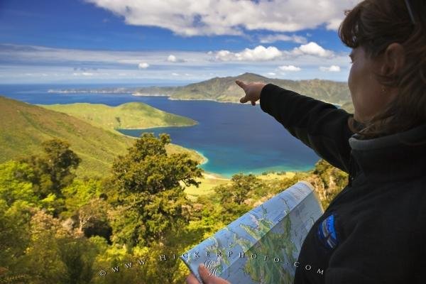 Photo of a woman pointing in the direction of the scenic coastal bay ...
