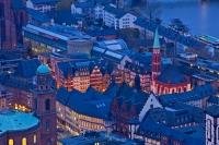 An aerial view of the Roemerberg at dusk, which is the City Hall Square in the City of Frankfurt in Germany shows the architecture and design of an old town perfectly. The buildings are clustered around the main square.