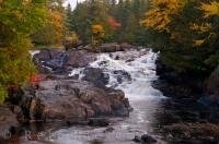 A waterfall along a river that winds through Mont Tremblant Provincial Park in Quebec with the Autumn colors highlighting the scenery.