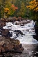 A beautiful scene in Quebec, a waterfall called Chutes Croches tumbles in cascades along the Riviere du Diable surrounded by a typical autumn scene of colourful maples and birch trees.