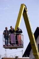 The Bavarian people use a crane as transport to watch the festivities at the Maibaumfest in Putzbrunn in Southern Bavaria.
