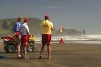 Beach Boys aka Surf Life guards on patrol in Piha Beach keeping watch over surfers and swimmers