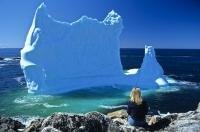 A large beached iceberg reflects shades of blue near the village of Twillingate in Newfoundland, Canada.
