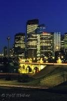 High rise buildings stand out against the night sky with bright lights blazing from within in downtown Calgary, Alberta, Canada.