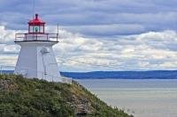 High on a cliff in Albert, New Brunswick, stands the Cape Enrage Lighthouse with its bright red roof and light which aids the water vessels.