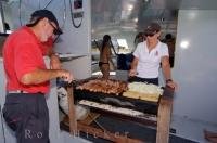 The crew aboard the Carino, a fifty foot catamaran, prepare lunch for the passengers who have come for an excursion around the Bay of Islands in New Zealand.