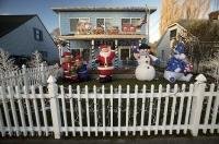 A white picket fence clad in christmas lights and inflatable christmas characters set the scene for the seaon.