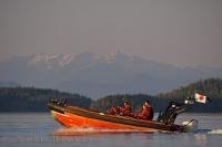 The Canadian Coast Guard cruise the waters of Johnstone Strait during sunset in British Columbia, Canada.