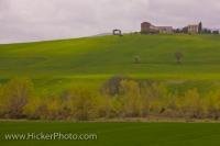 A beautiful country house looks out over the landscaped area in Tuscany in the Province of Siena, Italy in Europe where it sits high atop the hillside.