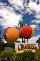 A brightly colored fruit sculpture and a sign reading Cromwell, Lake Dunstan welcomes visitors to this unique town in Central Otago, New Zealand.