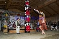 Dancer wearing a Traditional Mask in front of a Totem Pole on Vancouver Island B C