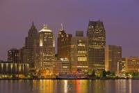 The skyline of Detroit City in Michigan USA is lit up at dusk with the lights of the buildings of offices and homes along the waterfront. This view is taken from the waterfront of Windsor Ontario, which is located in Canada.