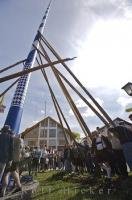 The European townspeople are holding the Maibaum in place by way of the historic method of using poles in Putzbrunn, Germany.