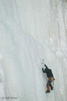 A climber mid way through climbing up a frozen waterfall, the Montmorency Falls in Quebec, Canada.