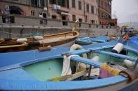 Colorful boats docked in the harbour of the Cinque Terre village of Vernazza in Italy below the waterfront walkway.