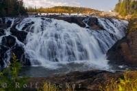 Massive amounts of water from High Falls rush over the rock ledges on their journey down the Magpie River in Wawa, Ontario in Canada.