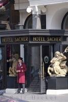 The bellhop waits outside the entrance to the Hotel Sacher in Vienna, Austria to assist guests with their luggage or transportation.