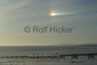 Stock photo of a sun dog with the alaskan oil pipeline in northern Alaska.