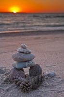 As sunset closes in around Agawa Bay in Lake Superior Provincial Park in Ontario, Canada, an Inukshuk decorates the coastline.