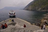 A small passenger ferry transports visitors between the villages of the Cinque Terre in Liguria, Italy with this trip arriving in the harbour of Vernazza.