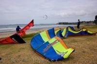 Two men rest on the shore of Orewa Beach on the North Island of New Zealand as they rearrange their kitesurfing gear for another round of excitement.