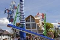 A business sign being hoisted up to be attached to the Maibaum in Putzbrunn, Southern Bavaria.