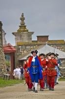 A military procession marches in the Quay at the Fortress of Louisbourg in Cape Breton, Nova Scotia in Canada before the cannon gun is fired.