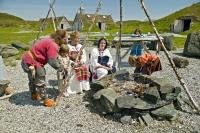 Stock photo of Vikings around an open fire place at the Norstead Viking site a viking port of trade.