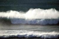 The wind whips at the top of a Pacific Ocean roller along the Oregon Coast, USA.