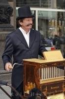 A man enjoys playing his organ grinder for people who pass by near the Stephansdom in downtown Vienna in Austria, Europe.