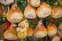 Tasty Prosciutto Hams hanging on a stall in the Central Markets in the City of Florence in Italy, Europe.