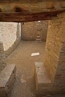 A room or chamber which leads to a series of doors is entered under a wooden transom and beside what looks like a pair of stone seats at Pueblo Bonito, Chaco Culture National Historic Park.