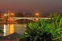 The Puente de Isabel II (bridge) crosses the Rio Guadalquivir (River) is lit up at dusk in the city of Seville in Andalusia, Spain. This bridge crosses over to the Triana district in the city and the bridge is still in use today.