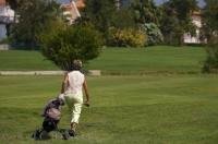 A woman walks the Oliva Nova Golf Course in Valencia, Spain with her clubs loaded into her pull cart.