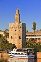 One of the many tourist tours are starting by boat in front of the Torre del Oro on the Rio Guadalquivir in Seville, Spain.
