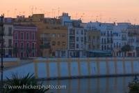 Sunset highlights the colorful buildings in the Triana District in the City of Sevilla in Andalusia, Spain where the Guadalquivir River flows.