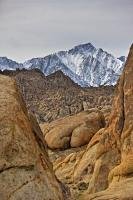 A view from amongst the rock formations of the Alabama Hills, looking towards the snow covered mountains of the Sierra Nevada.