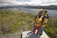Young couple overlooking the community of Woody point along the Viking Trail in western Newfoundland.