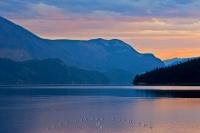 Beautiful and stunning Slocan Lake glistens with the last of the sun's rays at sunset. This view is taken from the town of New Denver in the Slocan Valley, which is located in the Central Kootenay region of British Columbia.